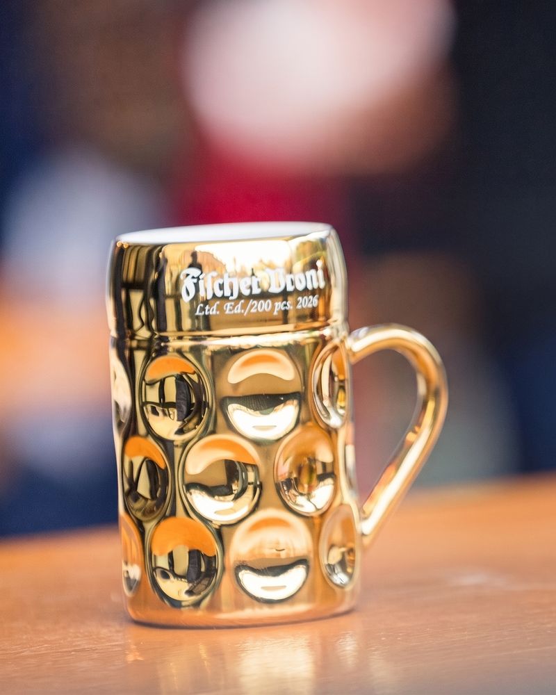 Goldener Fischer-Vroni-Krug, limitierte Edition 2026, auf einem Biertisch